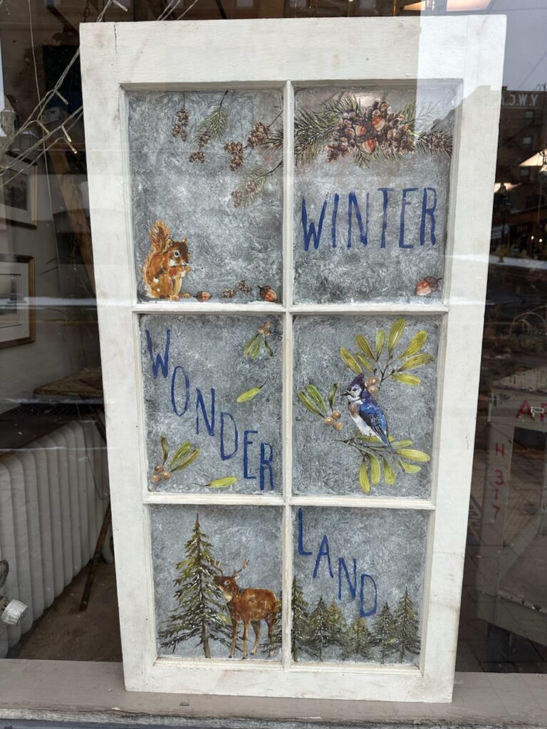 Old window frame reimagined with painted winter scenes.